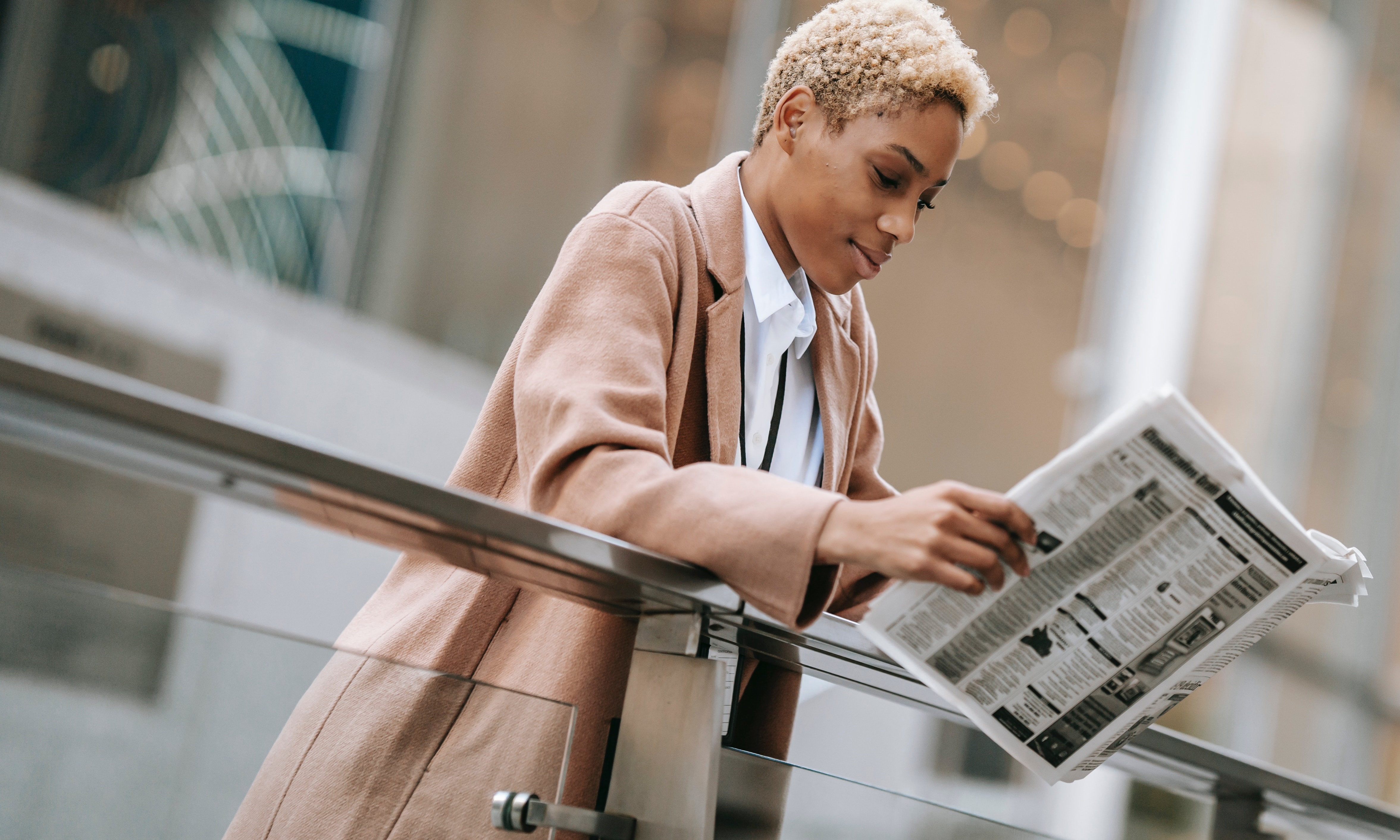 A woman is reading a newspaper